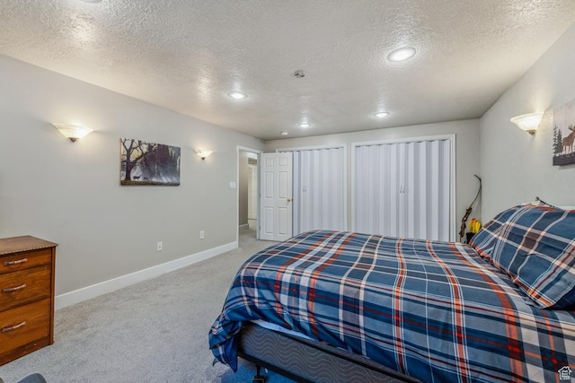 bedroom with a textured ceiling, light colored carpet, baseboards, and recessed lighting