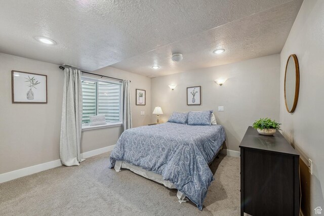 bedroom with a textured ceiling, carpet, and baseboards