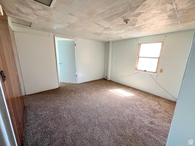 empty room with attic access and carpet