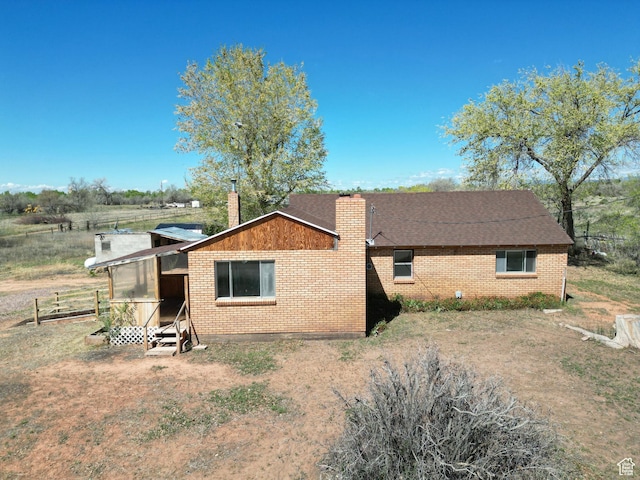 view of property exterior with a chimney and brick siding