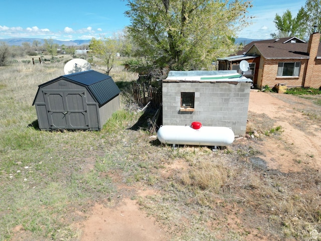 view of yard with a storage unit, an outdoor structure, and a mountain view