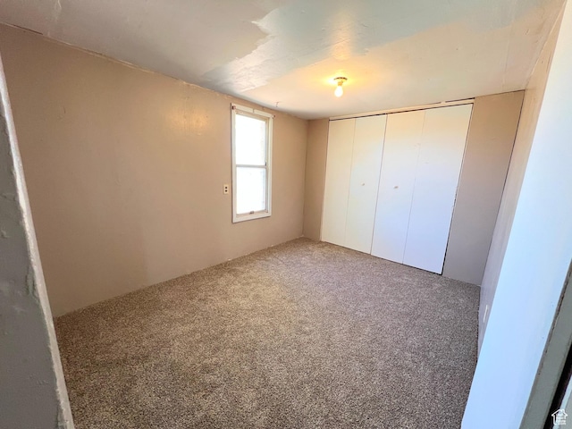 unfurnished bedroom with carpet flooring and a closet