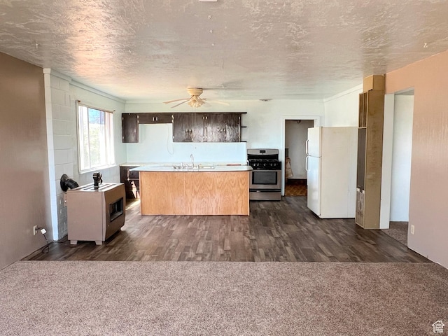 kitchen with gas stove, freestanding refrigerator, light countertops, ceiling fan, and a sink