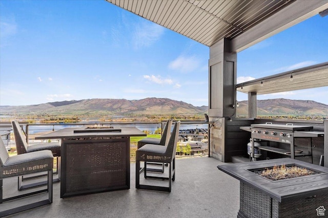 view of patio / terrace featuring an outdoor fire pit and a water and mountain view
