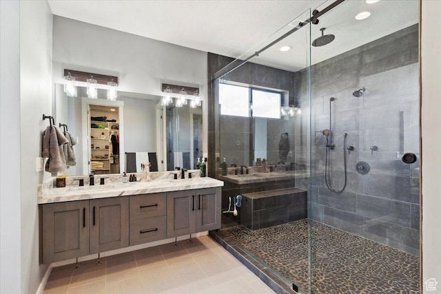 full bathroom featuring a shower stall, double vanity, tile patterned floors, a walk in closet, and recessed lighting
