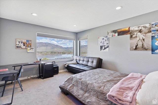 bedroom with carpet, recessed lighting, and a water view