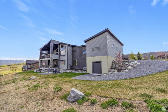 rear view of property featuring a balcony, a patio, and a yard