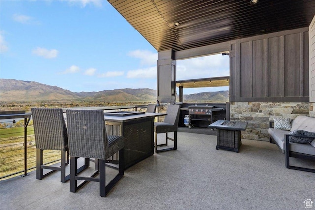 balcony featuring a mountain view, a patio, and an outdoor living space