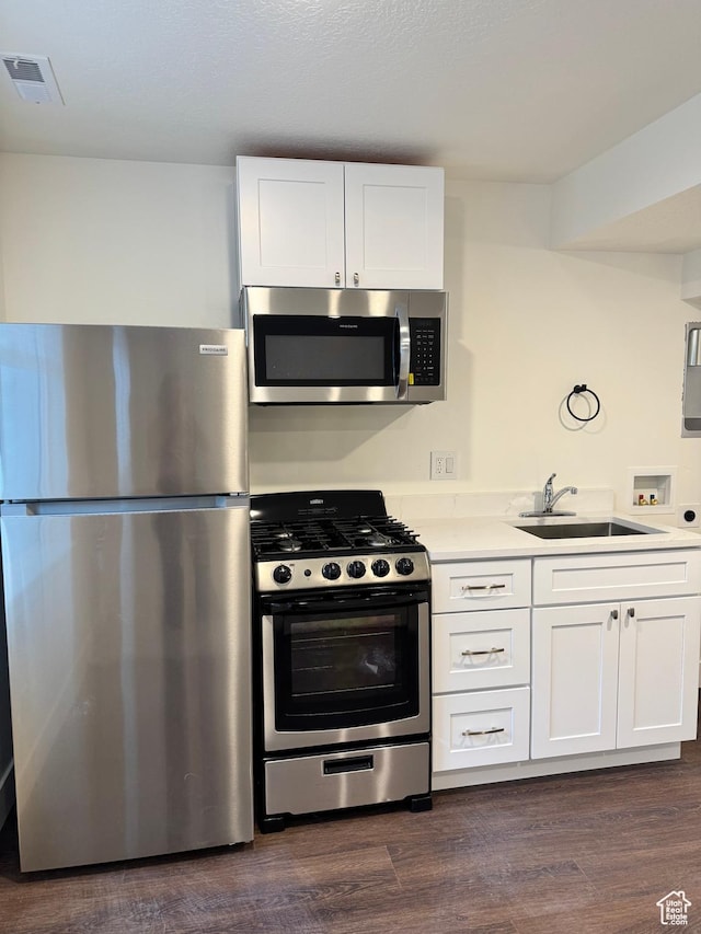 kitchen featuring stainless steel appliances, a sink, white cabinetry, and light countertops