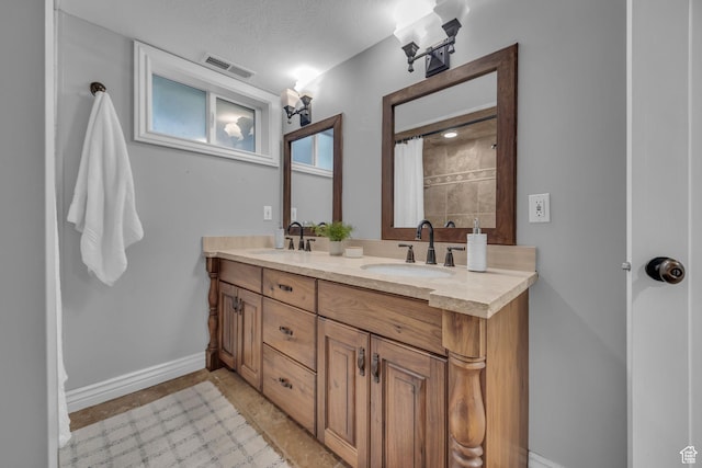 full bathroom with double vanity and baseboards