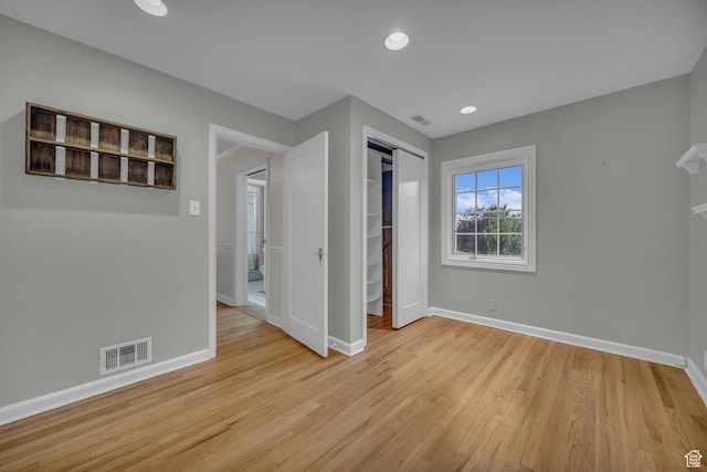unfurnished bedroom featuring baseboards, light wood-style flooring, a closet, and recessed lighting