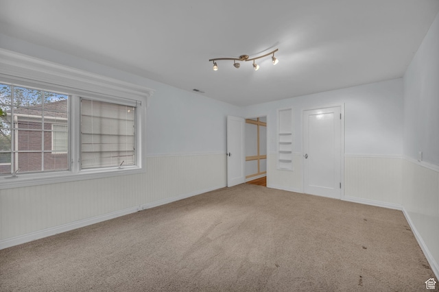 spare room featuring wainscoting and carpet flooring
