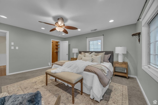 carpeted bedroom featuring multiple windows, baseboards, ceiling fan, and recessed lighting