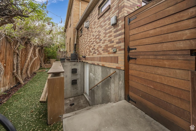 view of side of property with a fenced backyard and brick siding
