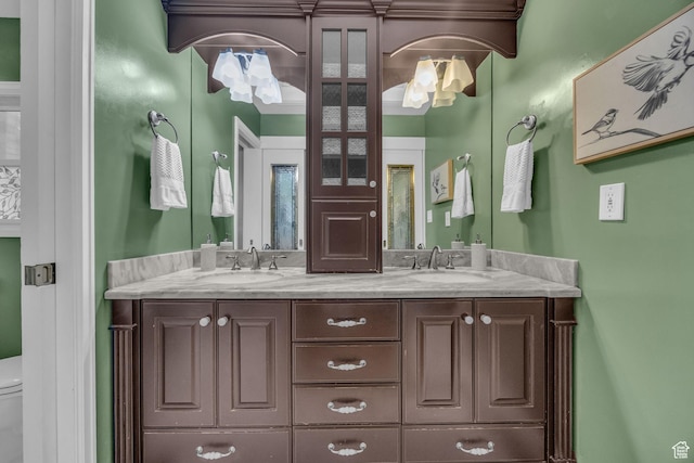 bathroom with toilet and double vanity