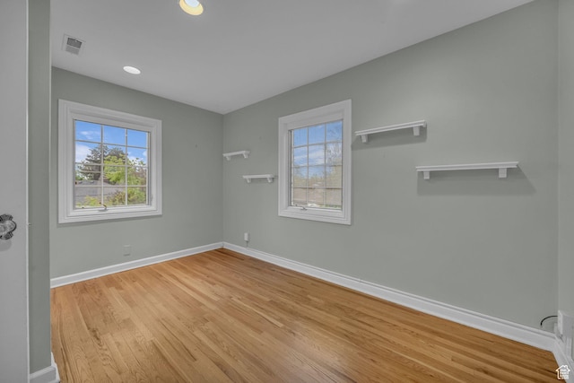 spare room with baseboards, wood finished floors, and recessed lighting