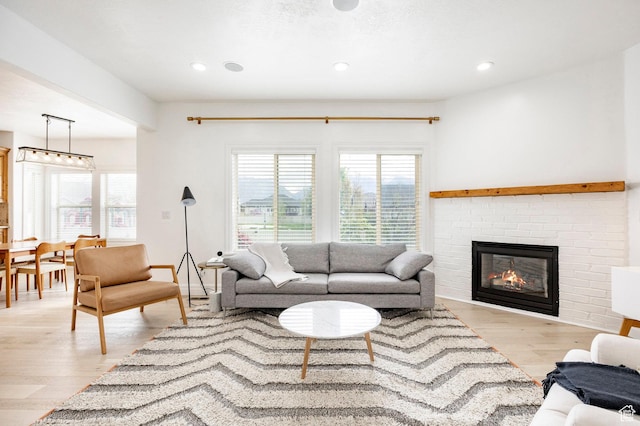 living room featuring light wood finished floors, a fireplace, and recessed lighting