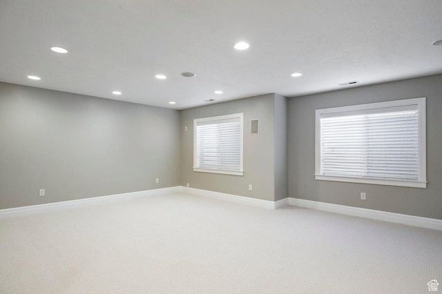 unfurnished room featuring light carpet, recessed lighting, baseboards, and healthy amount of natural light