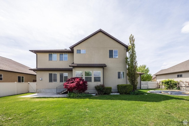 back of house with a gate, entry steps, stucco siding, and a patio