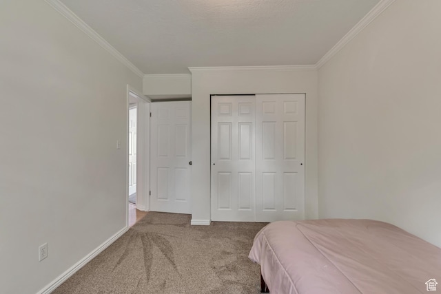 bedroom featuring carpet floors, ornamental molding, a closet, and baseboards