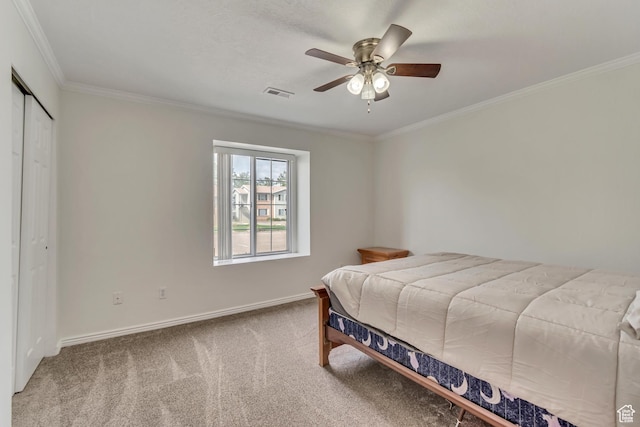 carpeted bedroom featuring ornamental molding, baseboards, a closet, and ceiling fan