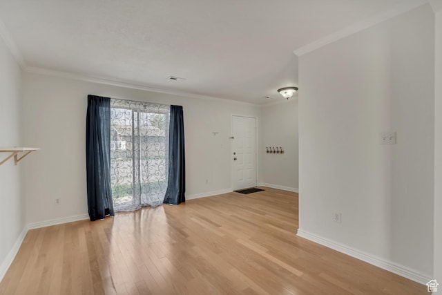 unfurnished room with light wood finished floors, baseboards, and ornamental molding