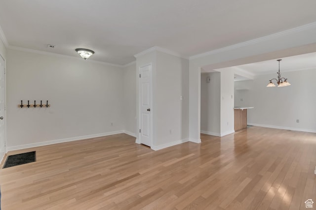 unfurnished room featuring a chandelier, light wood-style flooring, baseboards, and crown molding