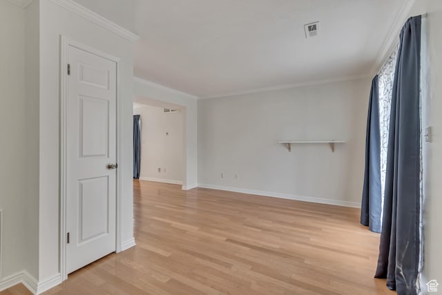unfurnished room featuring light wood-style floors, baseboards, and crown molding