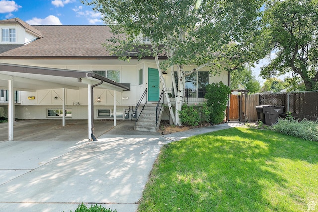 view of property featuring concrete driveway, roof with shingles, and a carport