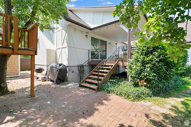back of house featuring a patio area, stairway, and board and batten siding