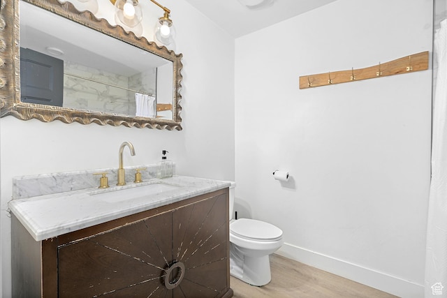 bathroom featuring wood finished floors, toilet, vanity, baseboards, and a shower with curtain