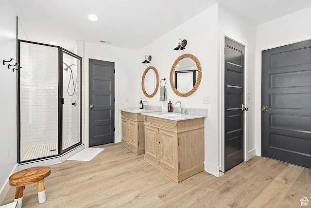 bathroom with a shower stall, wood finished floors, vanity, baseboards, and recessed lighting