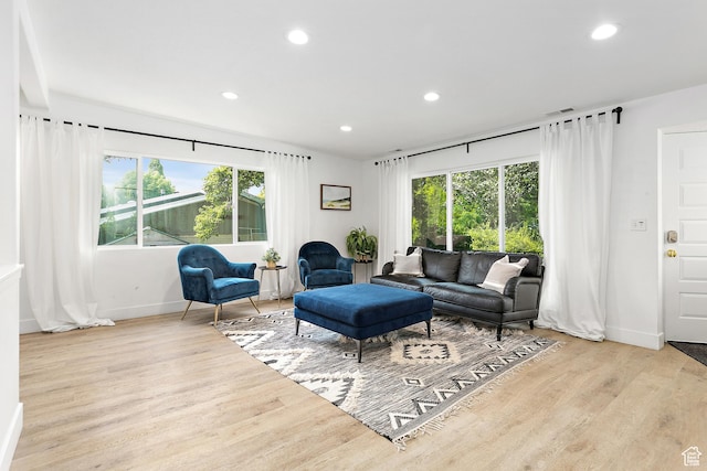 living room with baseboards, wood finished floors, and recessed lighting