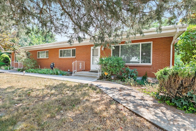 ranch-style home with brick siding and a front lawn