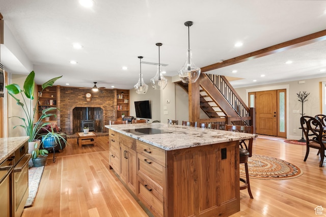 kitchen with open floor plan, light wood-style flooring, recessed lighting, a kitchen breakfast bar, and ceiling fan