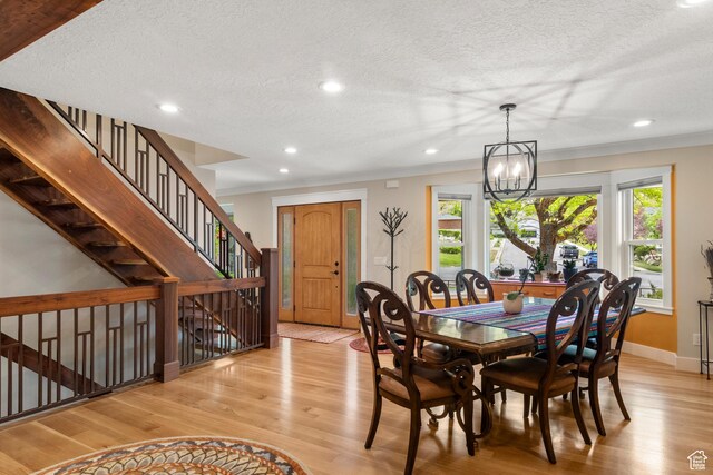 dining area with light wood-type flooring, a chandelier, a textured ceiling, recessed lighting, and baseboards