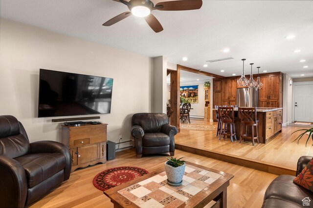living area with light wood-type flooring, a ceiling fan, recessed lighting, a baseboard heating unit, and baseboard heating