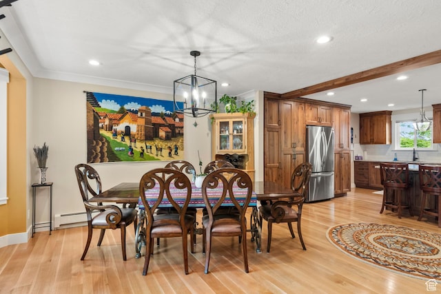 dining space with light wood finished floors, a chandelier, recessed lighting, a baseboard heating unit, and baseboards
