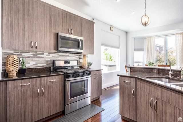kitchen featuring appliances with stainless steel finishes, a sink, healthy amount of natural light, and tasteful backsplash