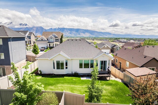 rear view of house featuring a residential view, a mountain view, a shingled roof, and stucco siding
