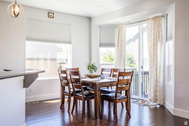 dining space featuring healthy amount of natural light, hardwood / wood-style floors, and baseboards