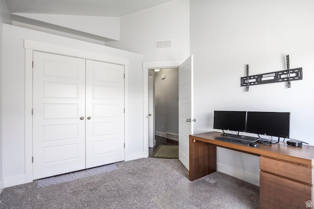 carpeted office featuring vaulted ceiling and baseboards