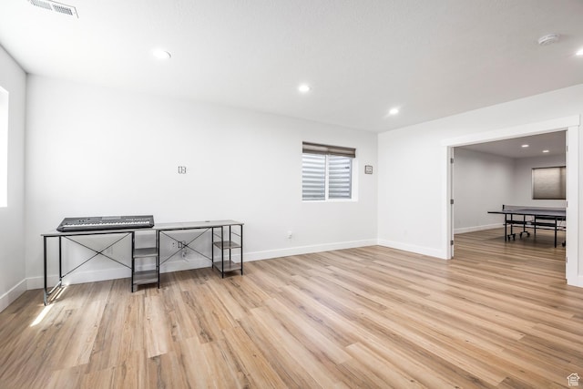 unfurnished room featuring light wood finished floors, recessed lighting, baseboards, and a smoke detector