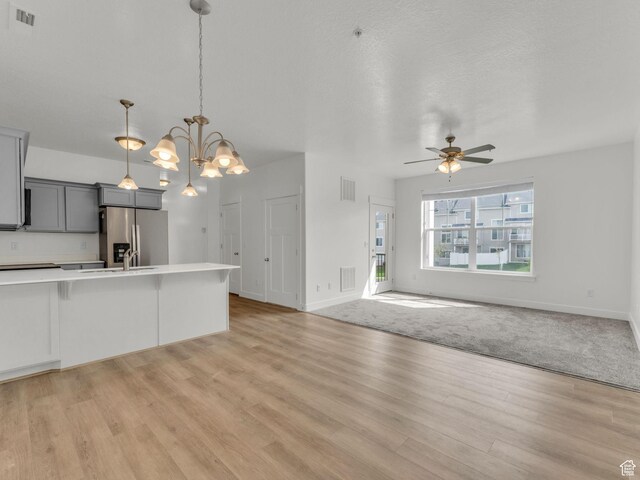 14514 S Ronan Ln W Unit T202, Herriman, UT 84096 - kitchen featuring stainless steel refrigerator with ice dispenser, light wood-style flooring, gray cabinets, light countertops, and open floor plan