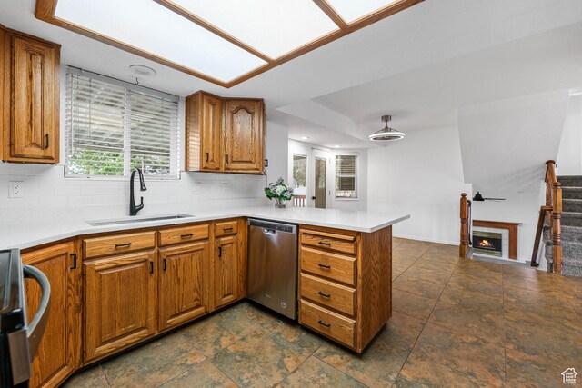 1888 W 1520 N, Clinton, UT 84015 - kitchen with a sink, dishwasher, a peninsula, brown cabinetry, and decorative backsplash