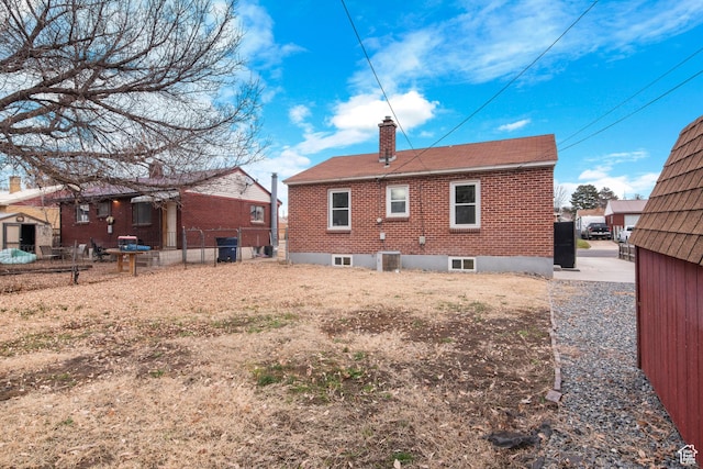 5857 S 2625 W, Roy, UT 84067 - back of property featuring a chimney, brick siding, and fence