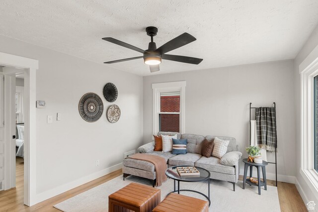 5857 S 2625 W, Roy, UT 84067 - living room featuring light wood-type flooring, ceiling fan, baseboards, and a textured ceiling
