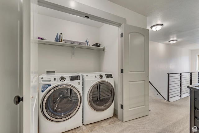clothes washing area with separate washer and dryer and light colored carpet