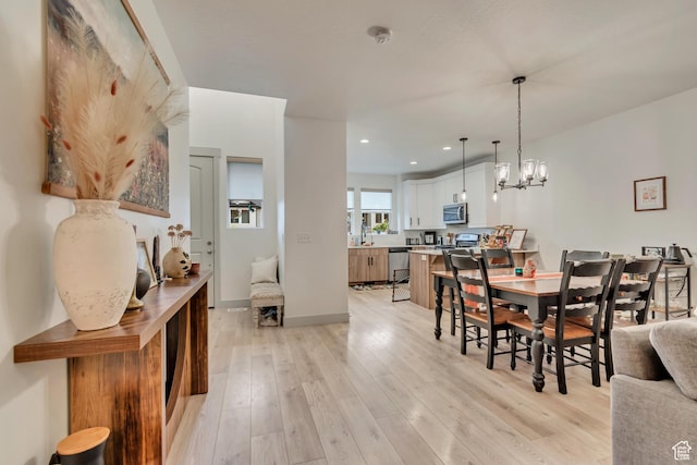 dining area featuring light wood-style floors, recessed lighting, a chandelier, and baseboards