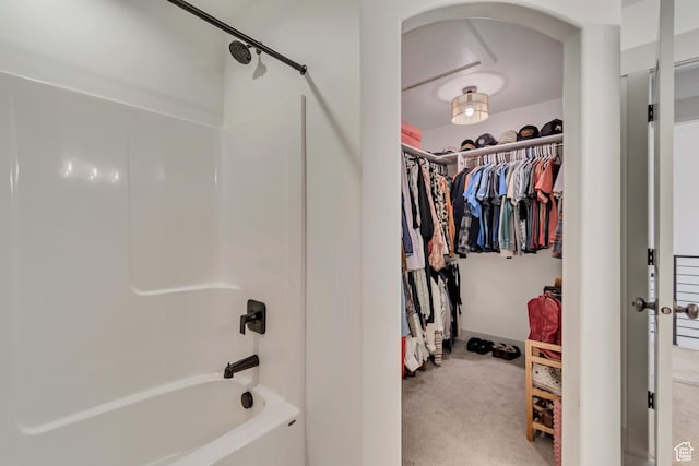 spacious closet featuring carpet flooring and arched walkways